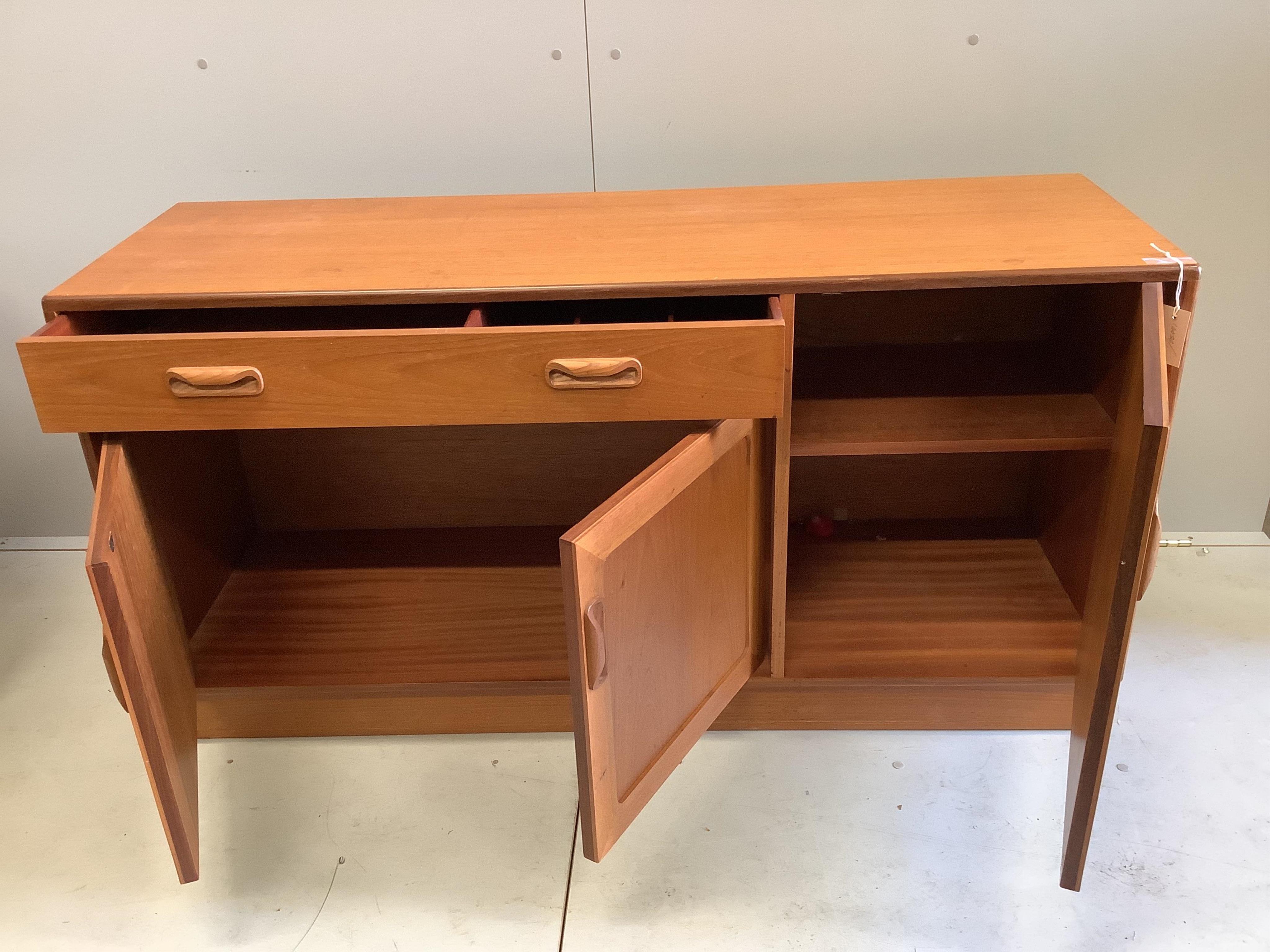 A mid century G Plan teak circular extending dining table, diameter 122cm, four chairs and sideboard, width 138cm, depth 44cm, height 72cm and a nest of tables. Condition - fair